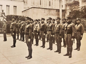 Pelotón de policías dedicado a la regulación del tránsito en las calles de San Juan. Monteagudo, Antonio M. ed., Escámez, Antonio ed. Álbum de oro de Puerto Rico: obra de divulgación cultural en pro de la fraternidad americana La Habana: Artes gráficas, 1939. 