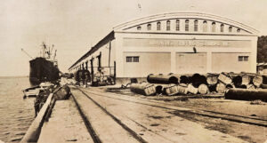 Muelle y almacén perteneciente a la Bull Insular Lines, en el puerto de MayagüezMonteagudo, Antonio M. ed., Escámez, Antonio ed. Álbum de oro de Puerto Rico: obra de divulgación cultural en pro de la fraternidad americana La Habana: Artes gráficas,1939.